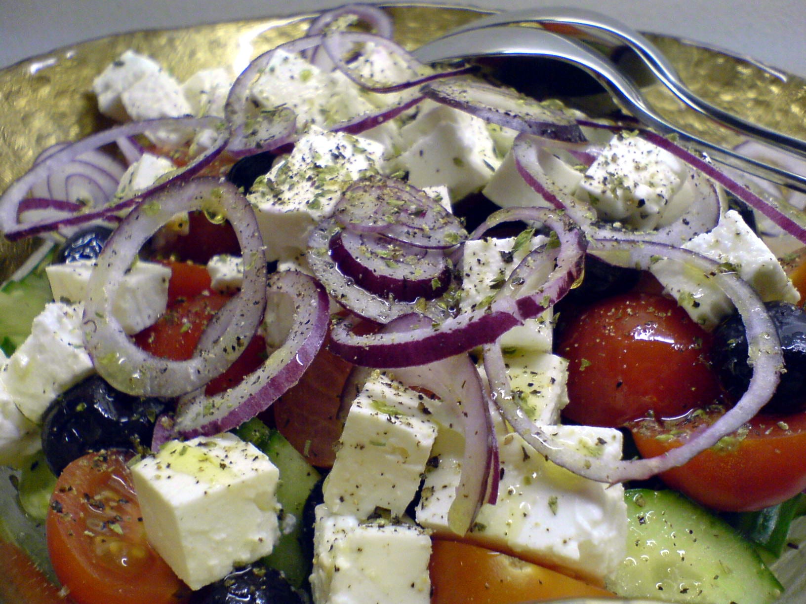 Greek village salad with tomatoes, cucumber, red onion rings, black olives and cubes of feta
